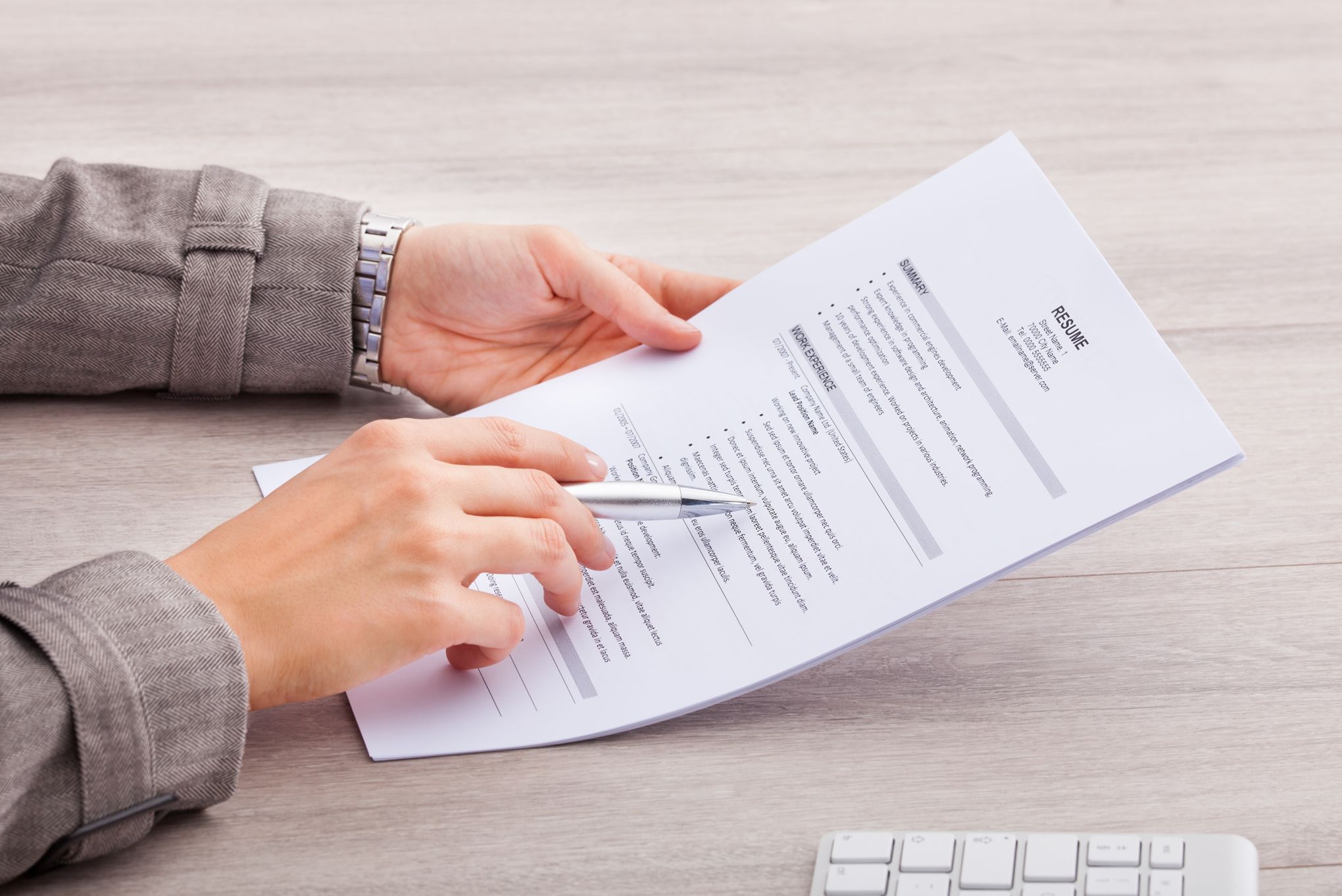 Close-up Of A Businesswoman At Desk Holding Resume